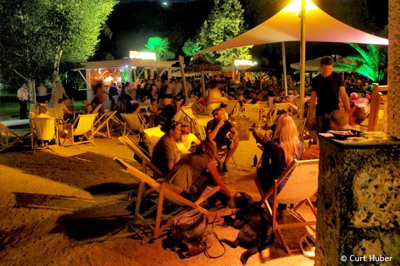 Personen auf Strandstühlen bei Nacht