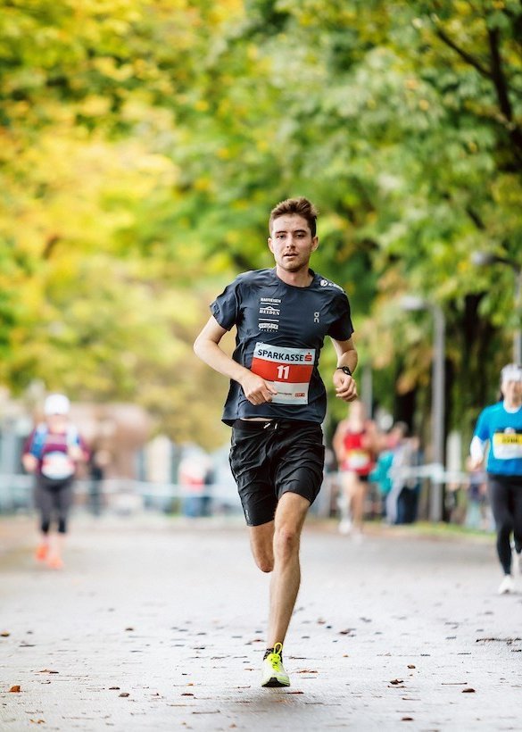 Läufer während dem 3 Länder Marathon zwischen Bäumen